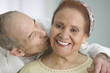 Elderly man kissing wife on the cheek