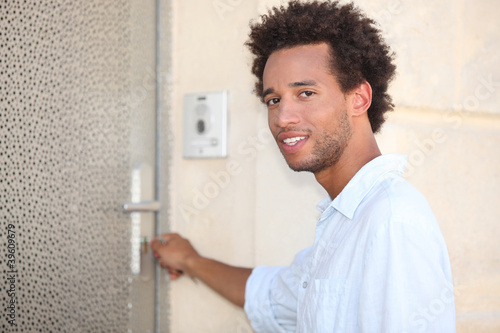 Photo: Man putting key in door Man putting key in door