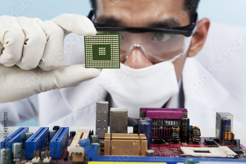 Photo: Scientist holding a Computer Microchip Scientist holding a Computer Microchip