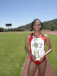 Winning female track athlete holding trophy