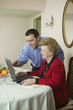 Son helping mom with laptop