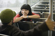 Two young adults talking on train