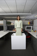 Businesswoman standing in office cubicle
