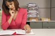 Businesswoman reviewing paperwork at desk