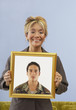 Proud mother holding picture of son