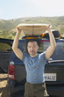 Man lifting surfboard from car rack