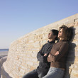 Young couple relaxing against a wall