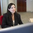 Woman sitting in office wearing earpiece