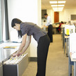 Woman looking through files in office