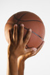 Close up of hand holding basketball in air