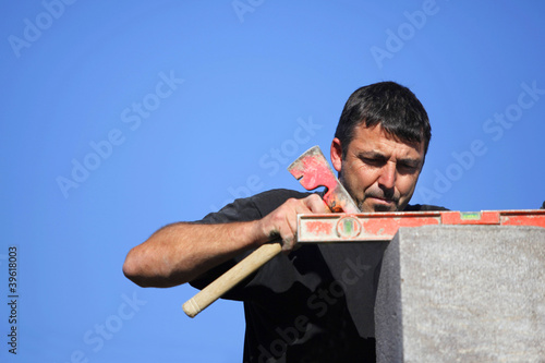 Photo: Tradesman using an axe and a bubble level Tradesman using an axe and a bubble level