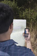 Rear view of man reading compass and map
