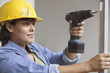 Woman construction worker with power drill and level