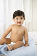Portrait of toddler boy sitting in diaper