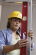 Woman construction worker in hard hat reading level measurements