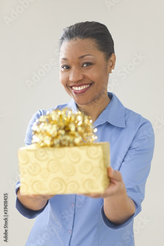 Photo: Woman smiling while offering a gift Woman smiling while offering a gift