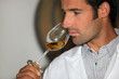 A man smelling wine