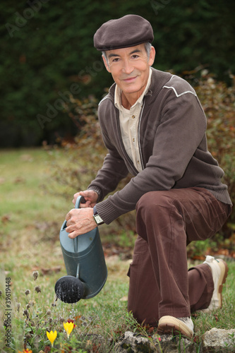 Photo: Man watering plants in his garden Man watering plants in his garden