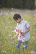 Boy picking wildflowers in field