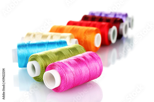 Photo: bright bobbin thread isolated on white. bright bobbin thread isolated on white.