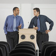 Two businessmen leaning on podium