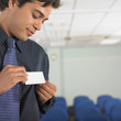 Businessman attaching name tag to jacket