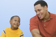 Father and young son smiling and looking at each other
