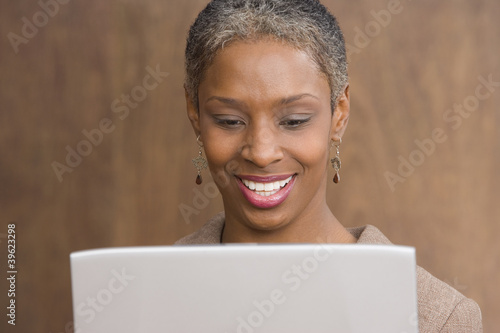 Photo: Close up of mid adult businesswoman with laptop Close up of mid adult businesswoman with laptop
