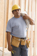Construction worker carrying wiring on shoulder
