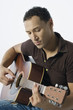 Young man strumming a guitar