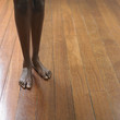 Young woman's bare feet on a hardwood floor