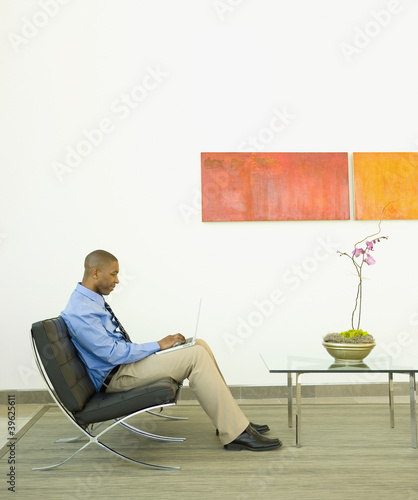 Photo: Businessman working on a couch Businessman working on a couch
