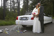 Newlyweds hugging by their car