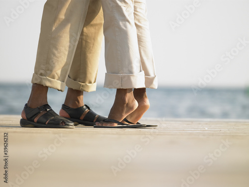 Photo: Couple's feet on a wooden deck Couple's feet on a wooden deck
