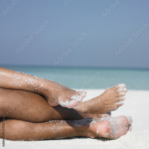 Photo: Couple's legs on the beach Couple's legs on the beach