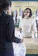 Asian drycleaner talking to customer