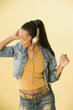 Studio shot of a Dominican woman dancing and wearing headphones