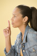Studio shot of a female Dominican teenager putting index finger to lips