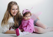 The small beautiful girl at mum on hands on a white background w