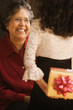 Hispanic granddaughter giving grandmother gift