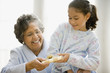 Hispanic granddaughter giving grandmother gift