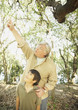 Hispanic grandfather and grandson in woods