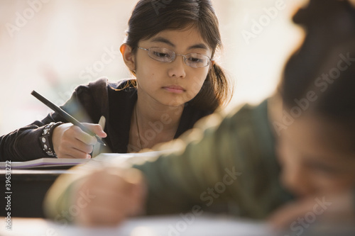 Photo: Young girl in classroom doing school work Young girl in classroom doing school work