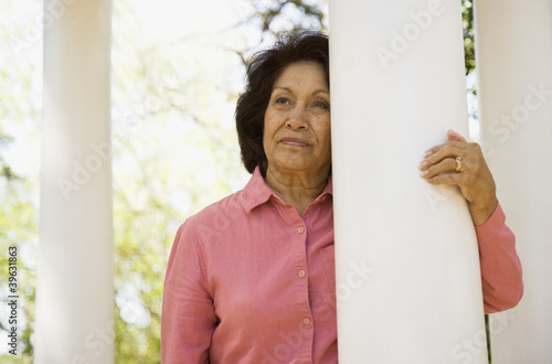 Photo: Senior woman leaning on column outdoors Senior woman leaning on column outdoors