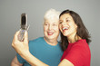 Mother and adult daughter taking own photograph with camera