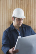 Hispanic man with hard hat and blueprints