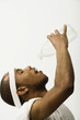 Studio shot of African man pouring water into mouth