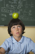 Boy with apple on head in classroom