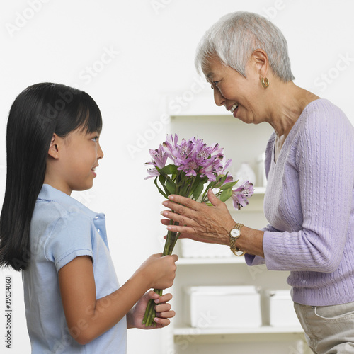 Photo: Asian girl giving grandmother bouquet of flowers Asian girl giving grandmother bouquet of flowers