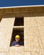 Construction worker looking out of window in unfinished building